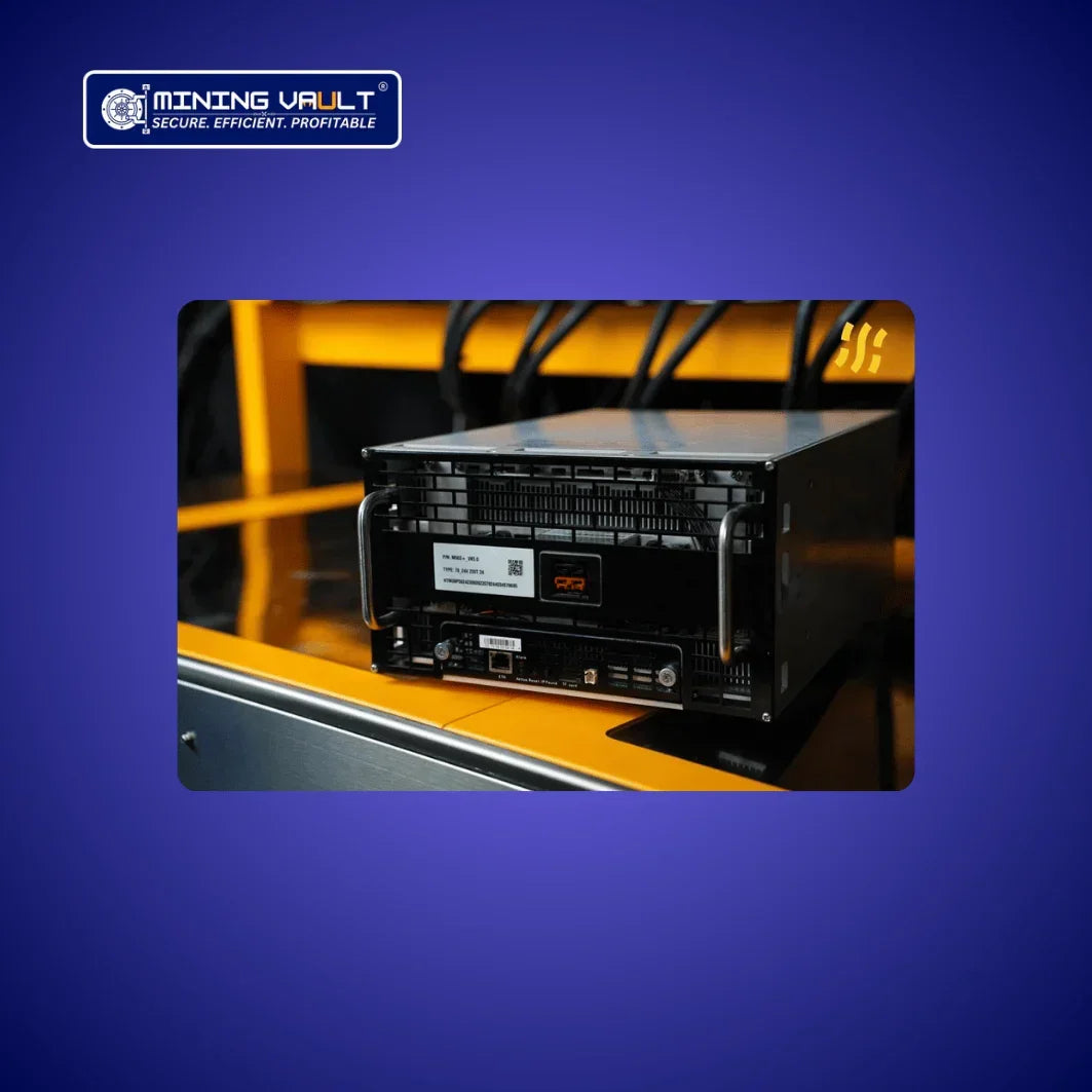 Appareil de minage crypto noir posé sur surface jaune avec câbles et logo Mining Vault